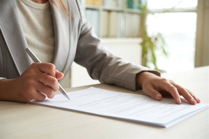 cropped-mid-section-of-unrecognizable-woman-signing-the-document.jpg